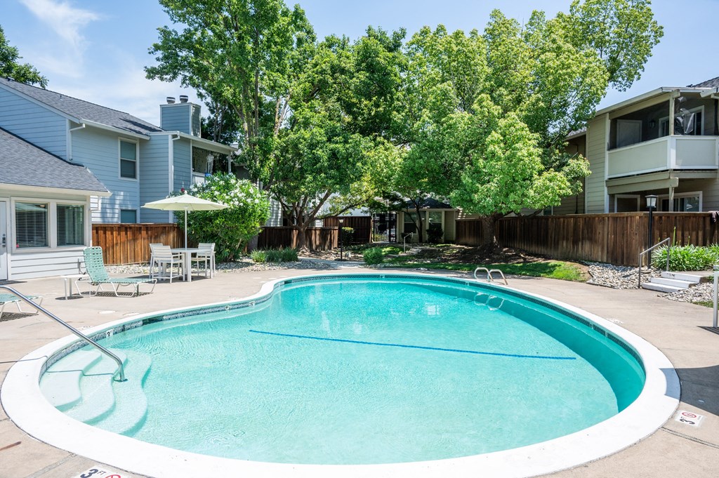 View of gated community pool at Creekside Colony with lounge chairs and seating