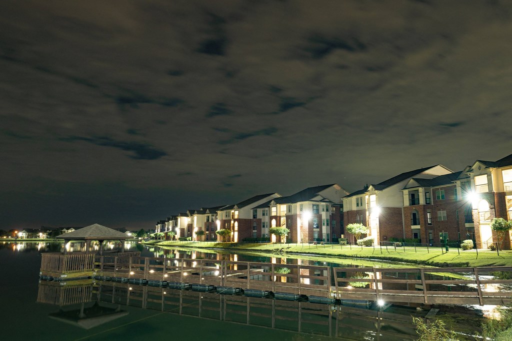 a row of apartments along a body of water at night