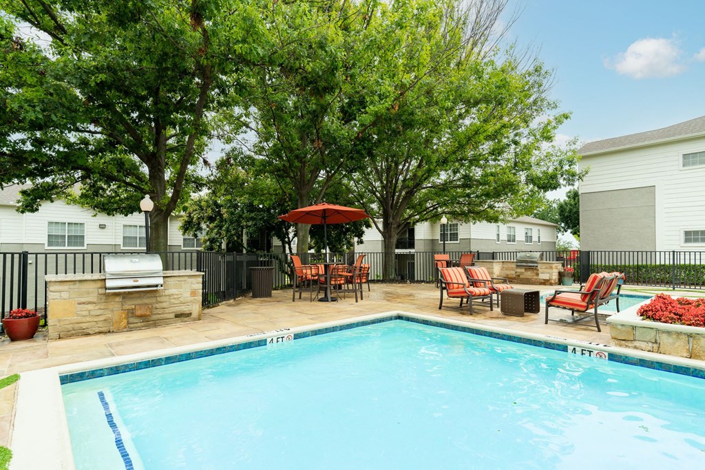 view of pool with grilling station and counter space to prep food, sitting area and lounge chairs