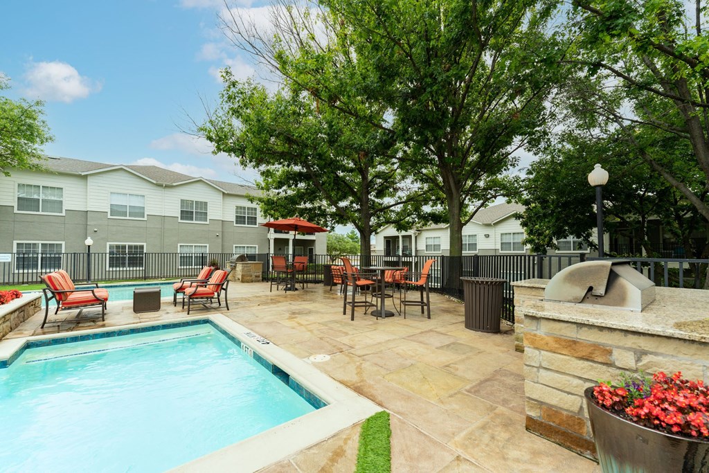 view of pool with grilling station and counter space to prep food, sitting area and lounge chairs