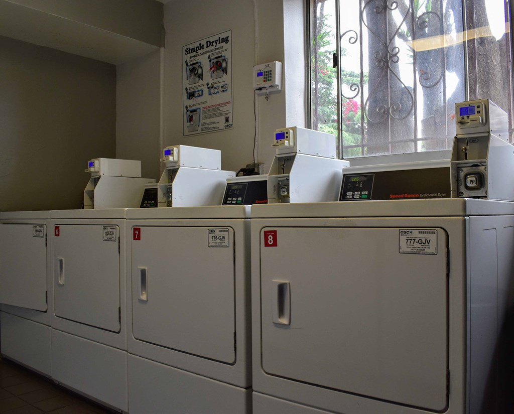 a row of washers and dryers in a laundry room