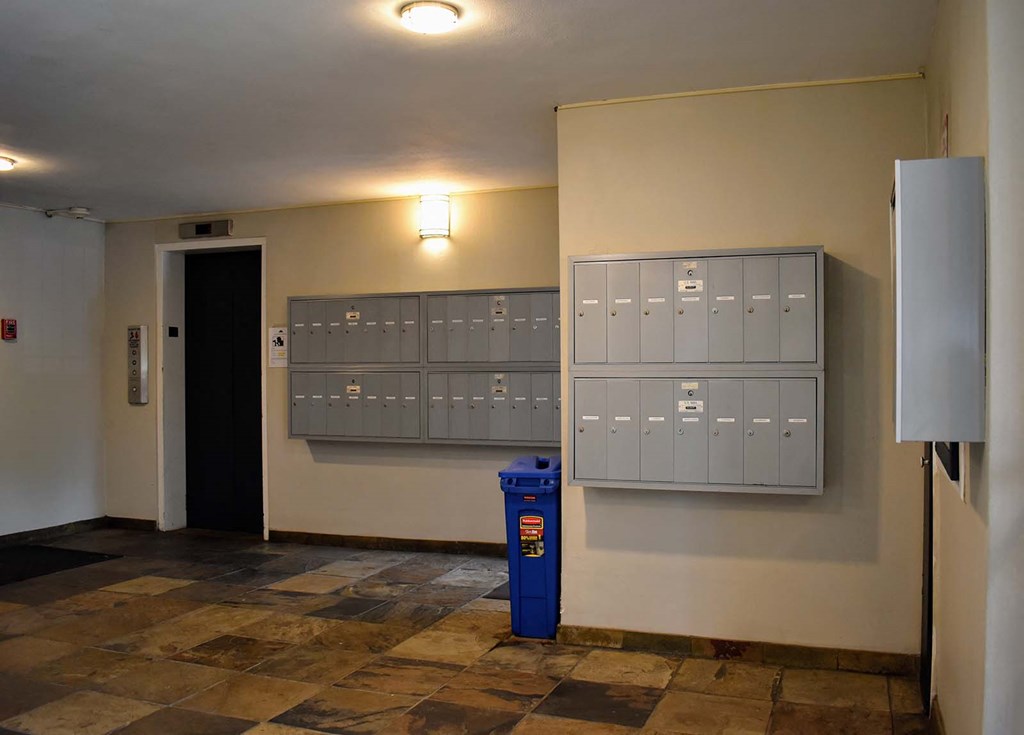 a locker room with mailboxes and a blue trash can