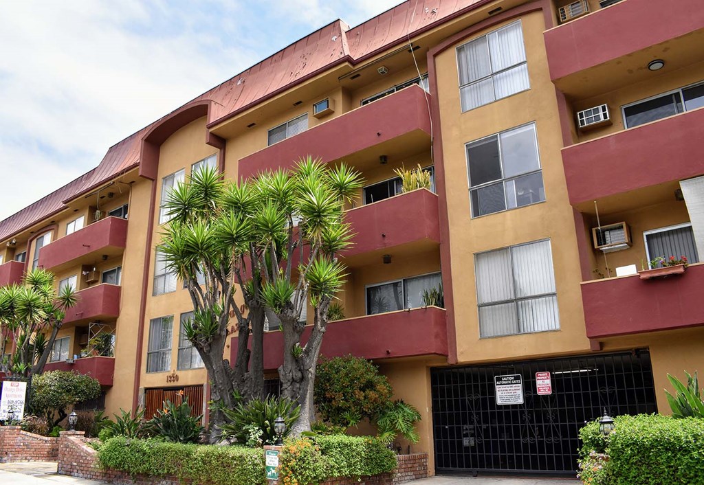 an apartment building with palm trees in front of it