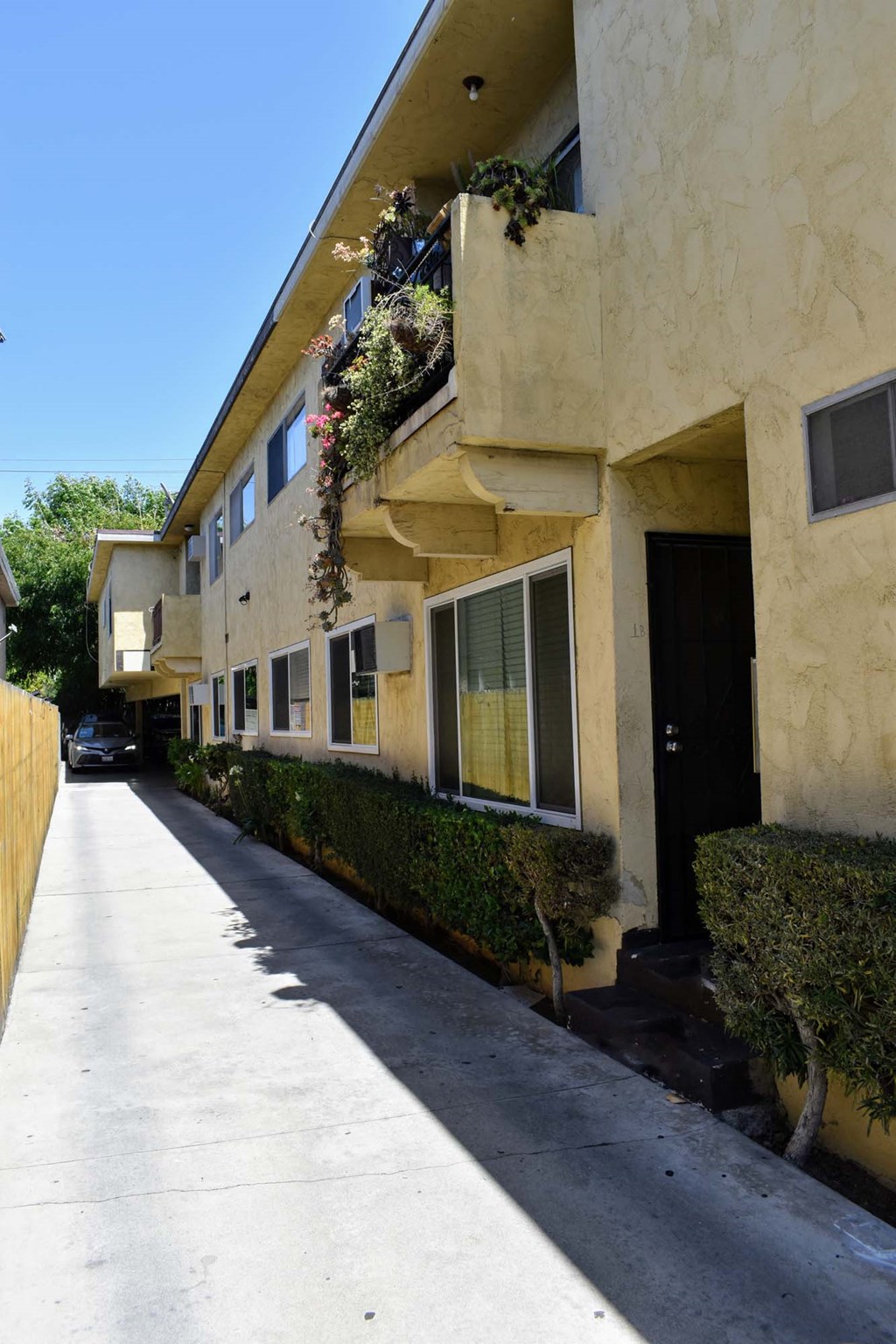 an empty sidewalk in front of an apartment building