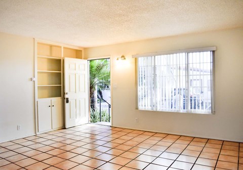 a living room with a sliding glass door and a tiled floor