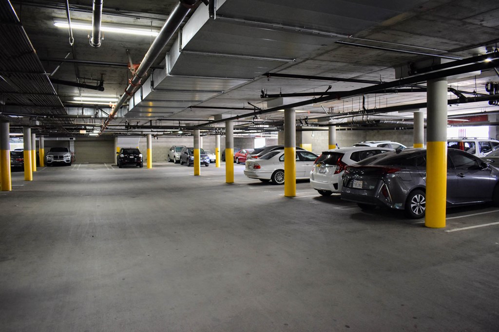 a parking garage with cars in it and yellow pillars