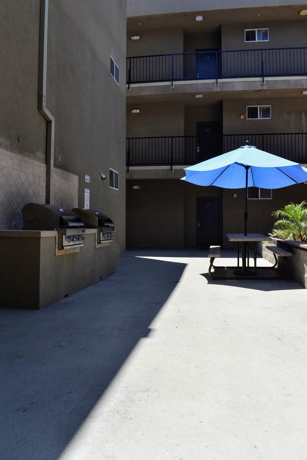 a picnic table with an umbrella outside of a building