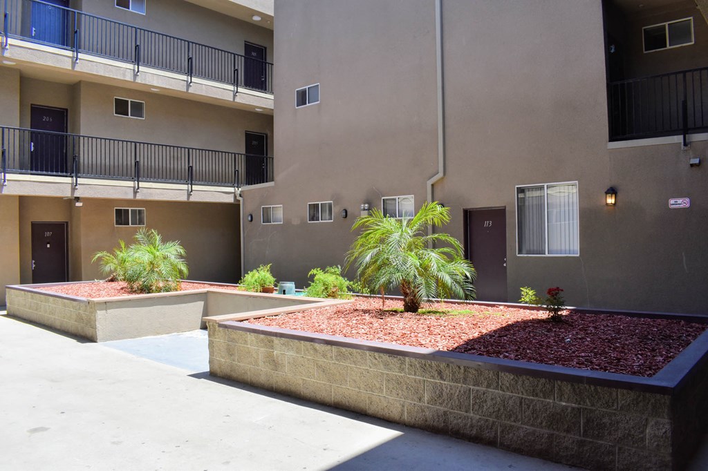 an apartment building with a courtyard and plants