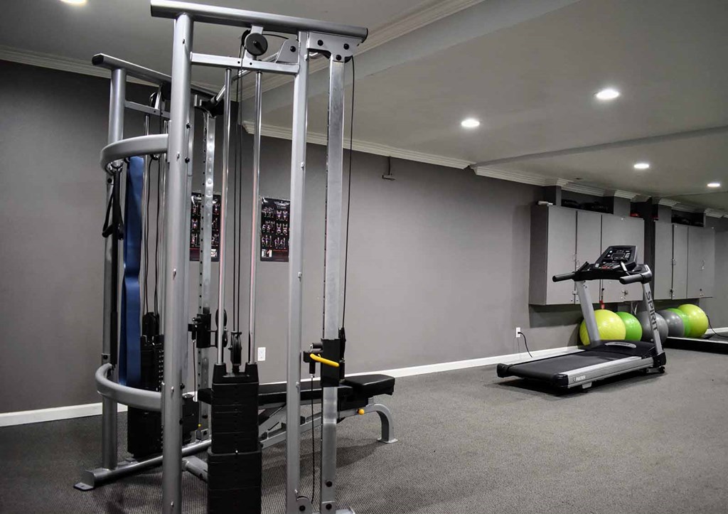 View of community gym featuring weight machines, treadmill, and exercise balls
