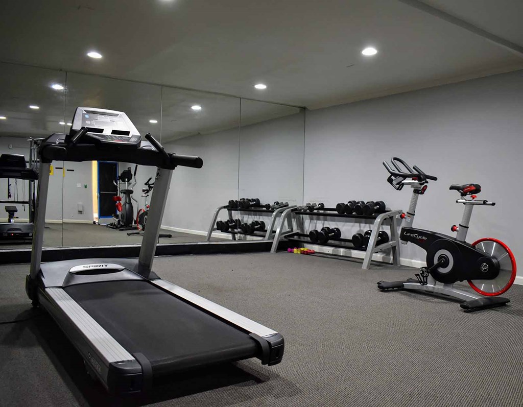 Community gym View of community fitness center with treadmill, stationary bike, and free weights