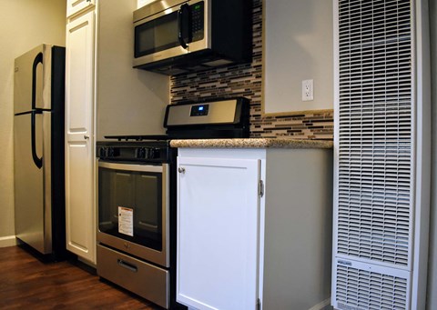 a small kitchen with a stove microwave and refrigerator