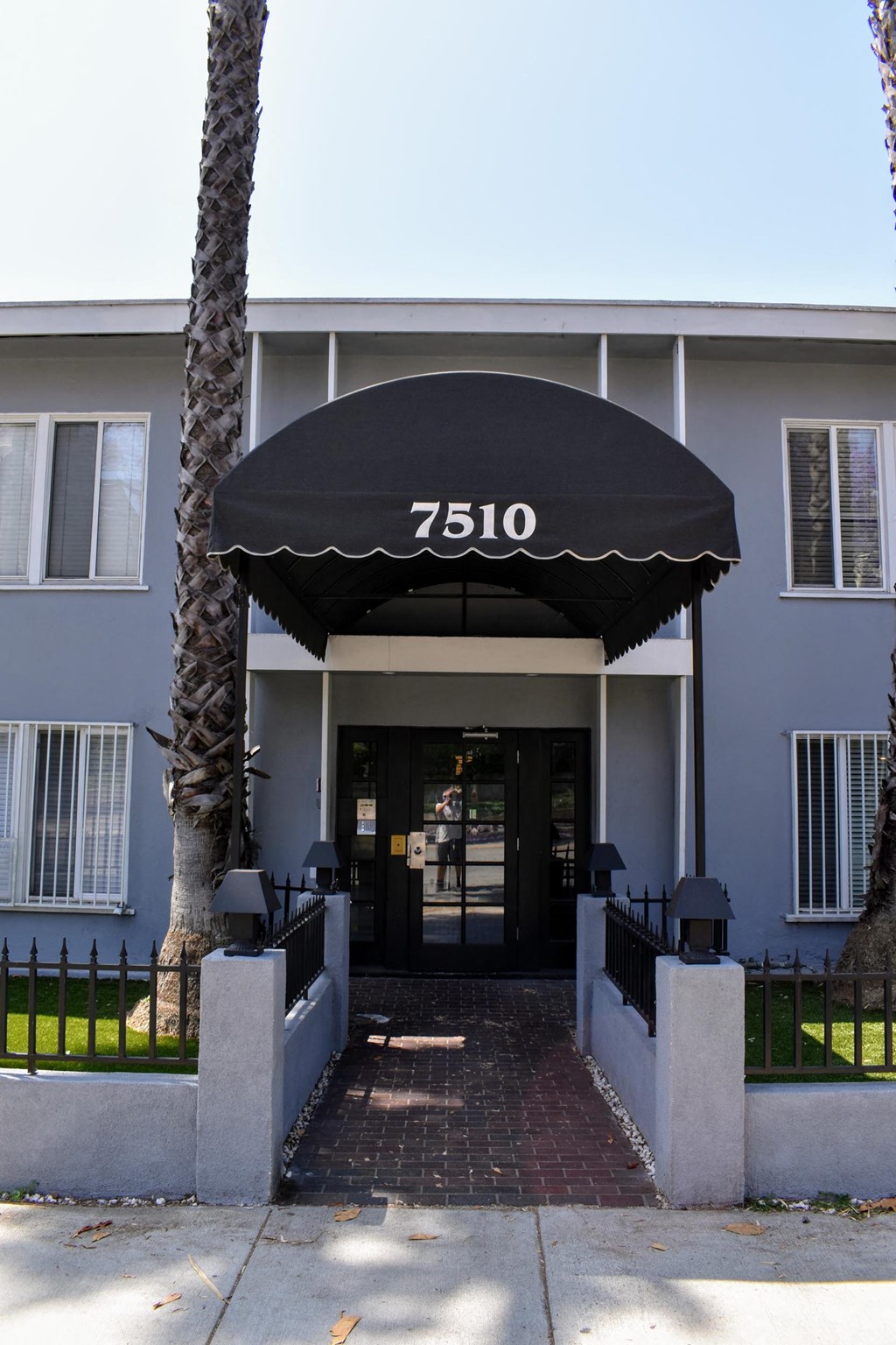the front of a blue building with a black awning