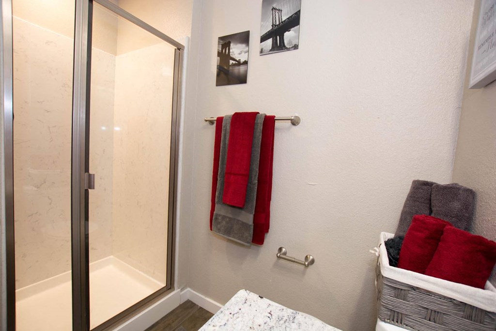 a bathroom with two red towels and a shower