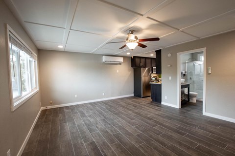 an empty living room with a ceiling fan
