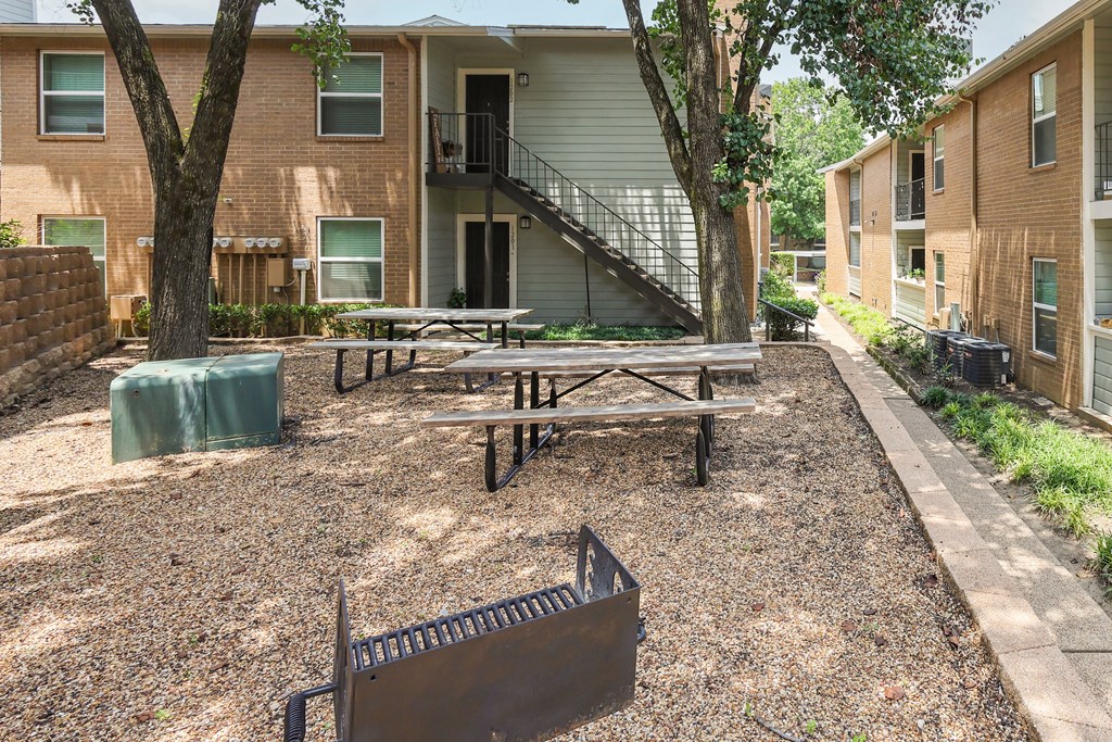 View of grilling station with picnic tables and shade trees