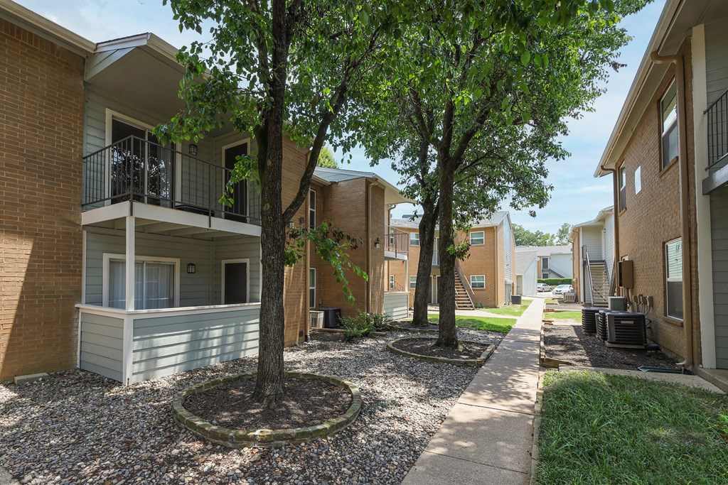 View of shaded sidewalk through property