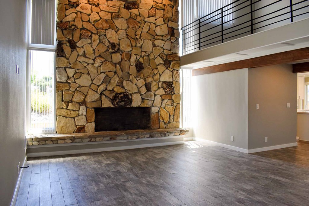 view of stone fireplace in living room with wood look flooring