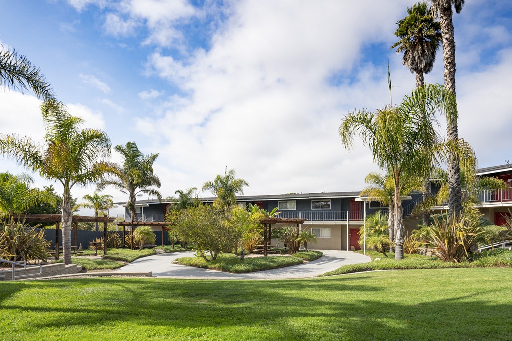 an apartment with palm trees in front of it