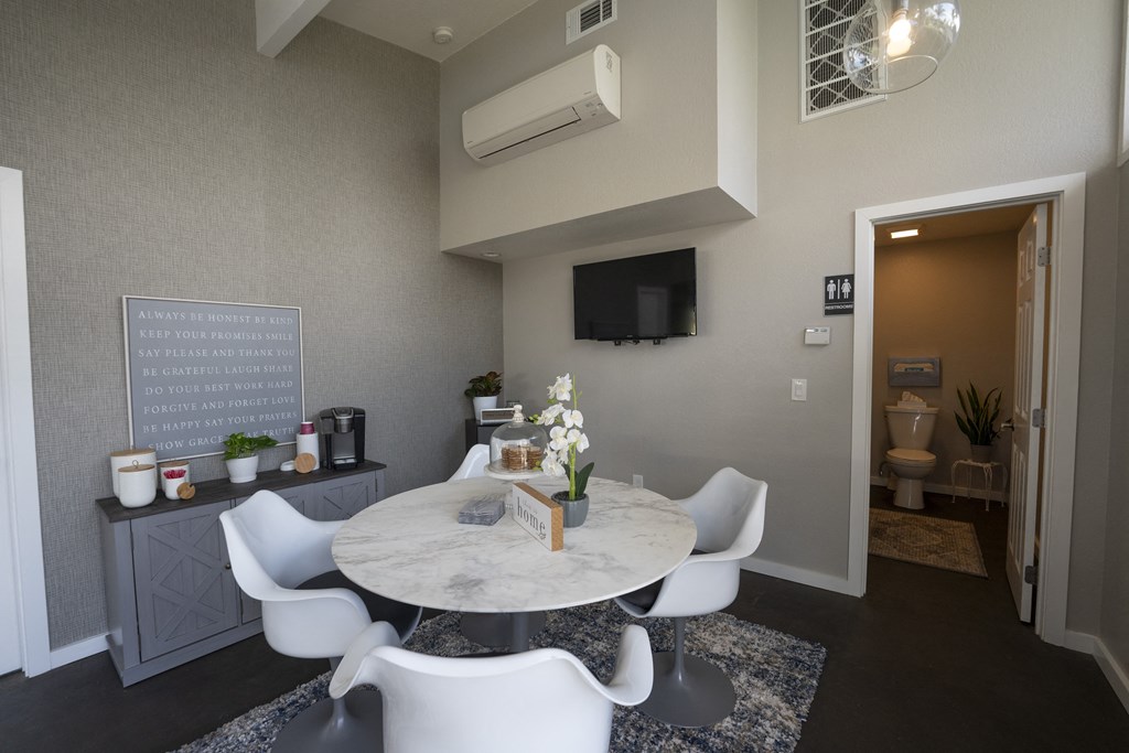 View of club room with a dining area with a table and chairs and a tv on the wall and coffee bar