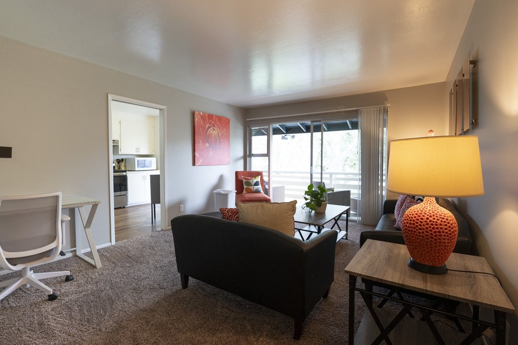 Living room view of furnished model apartment facing private patio/balcony