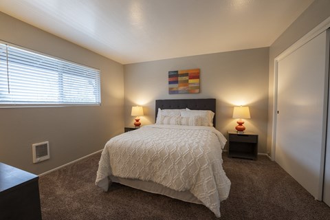View of furnished model bedroom with carpet flooring and well lit window