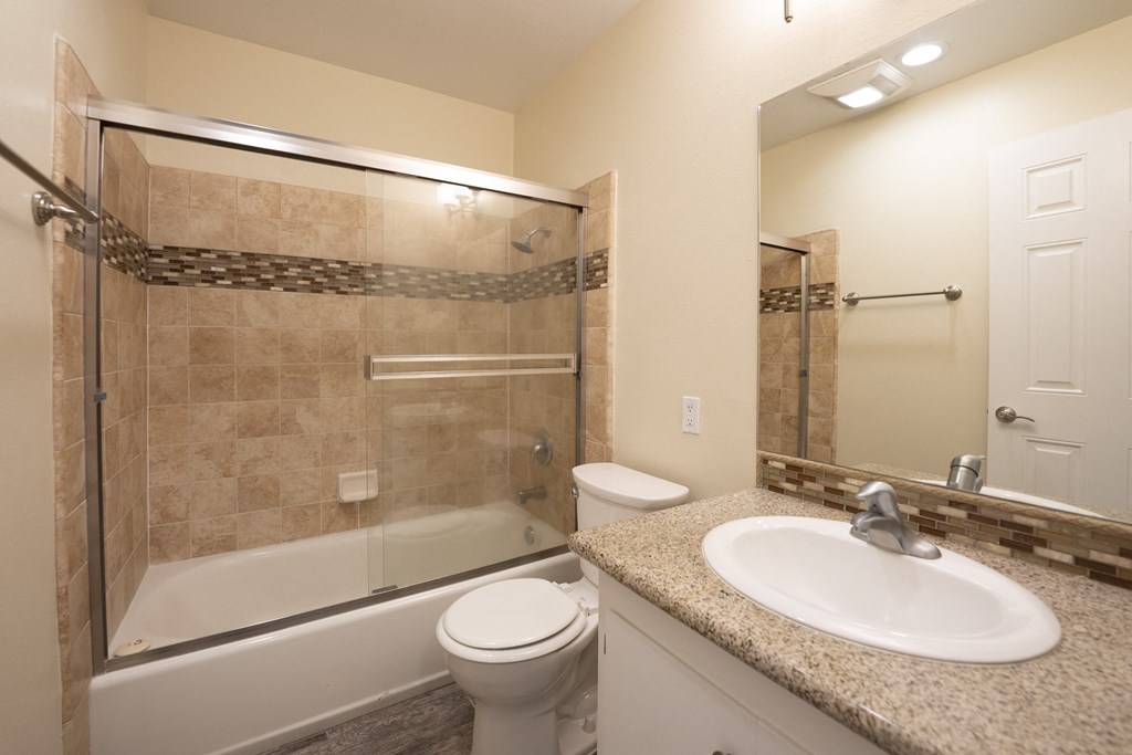 a bathroom with a shower toilet and sink