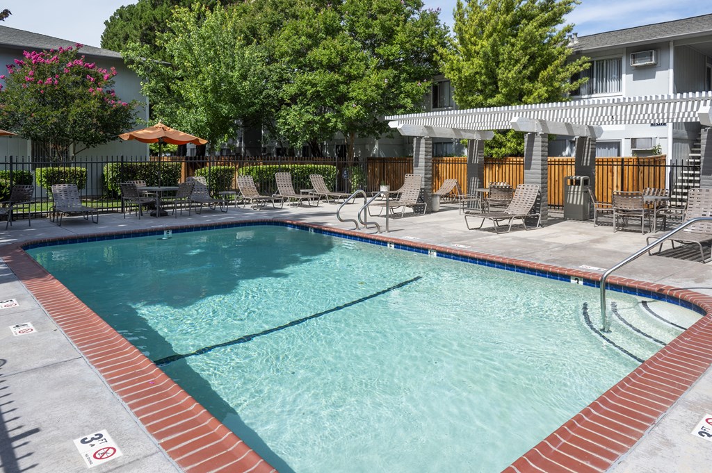 a swimming pool with chairs and a resort style pool