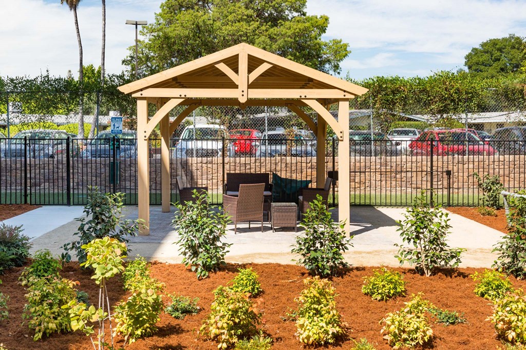 a patio with a table and chairs in a garden