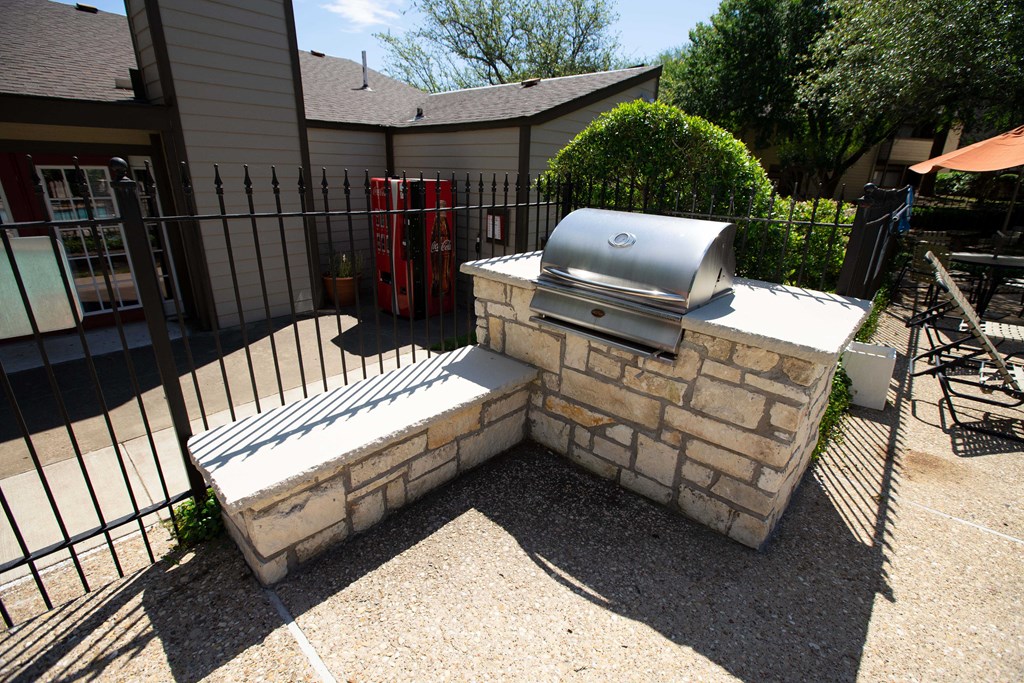 View of grilling station in fenced pool area with counters to prep food