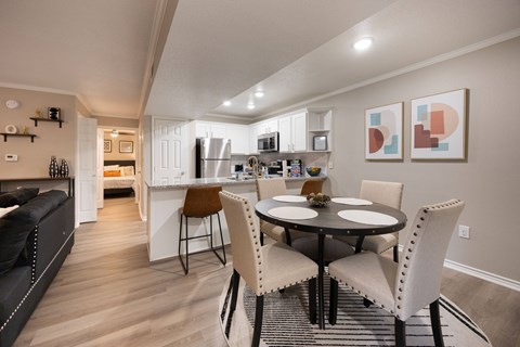 A modern kitchen with a dining table set for two.