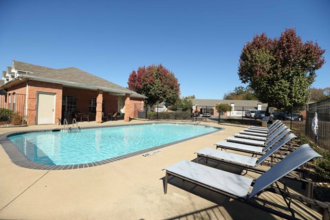View of gated community pool with lounge chairs and access to community gym