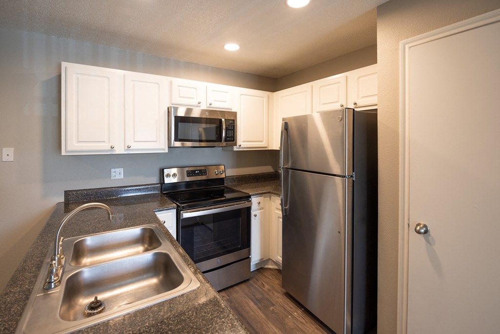 Alternate view of Riviera and Augusta open kitchen with dark counters, white cabinets, stainless appliances, pantry, and recessed lighting