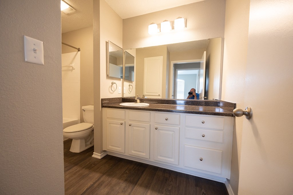 View of guest bathroom with vanity, large mirror, white cabinets, and medicine cabinet