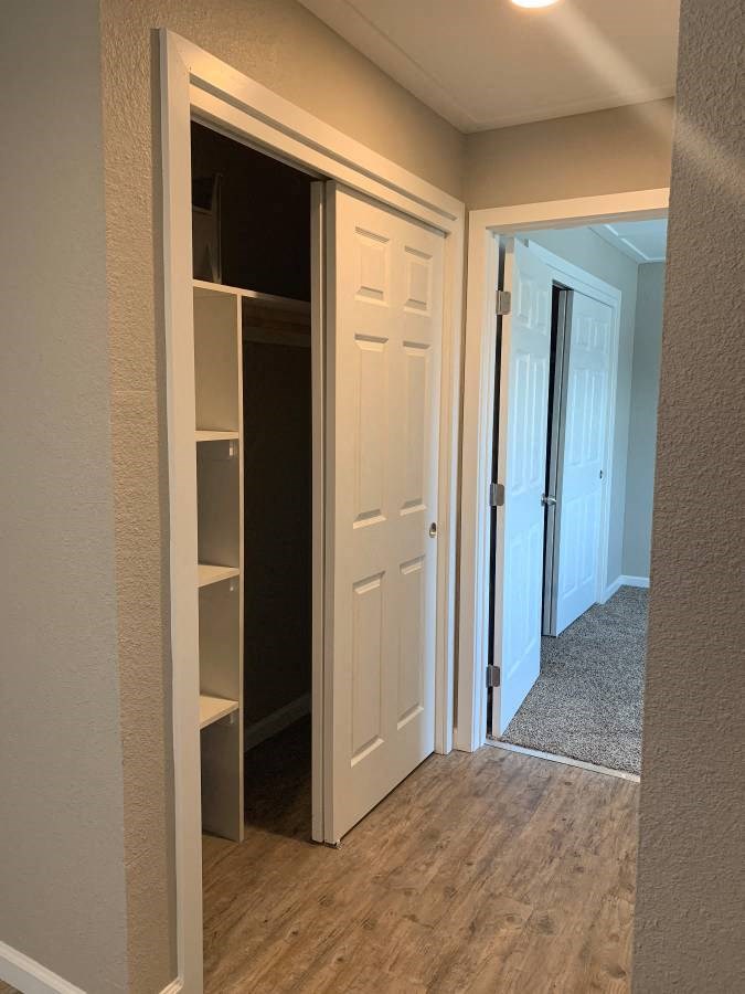 View of hallway with sliding door closet and built in shelving