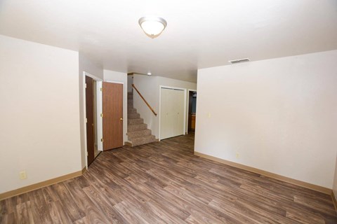 a renovated living room with a hard wood floor and white walls