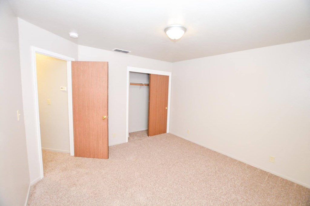 View of upstairs bedroom with carpet flooring and closet