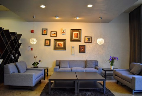 a living room with couches and pictures on the wall