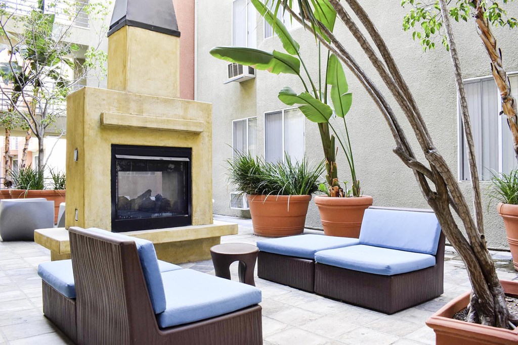 View of courtyard with fire place and seating and tropical plants