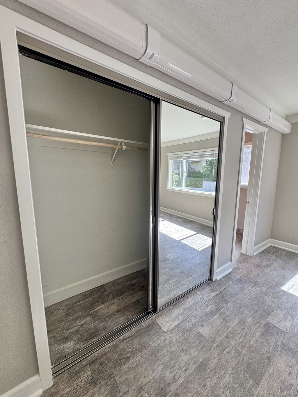 A room with a sliding glass door and a grey carpet.