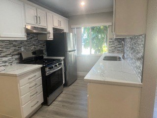 A kitchen with black appliances and white cabinets.