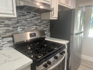 A kitchen with a black stove top oven and a black refrigerator.
