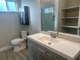 A bathroom with a toilet, sink, and mirror.