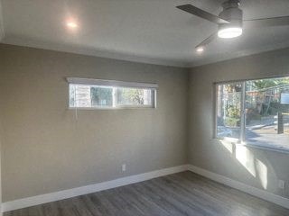 A room with a ceiling fan and a window.