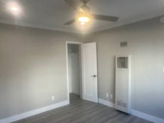 A room with a ceiling fan and a door.