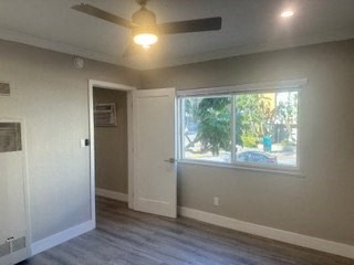 A room with a ceiling fan and a window.