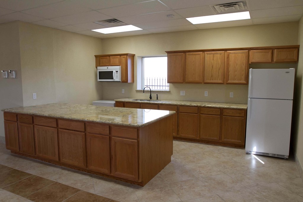 an empty kitchen with granite counter tops and wooden cabinets
