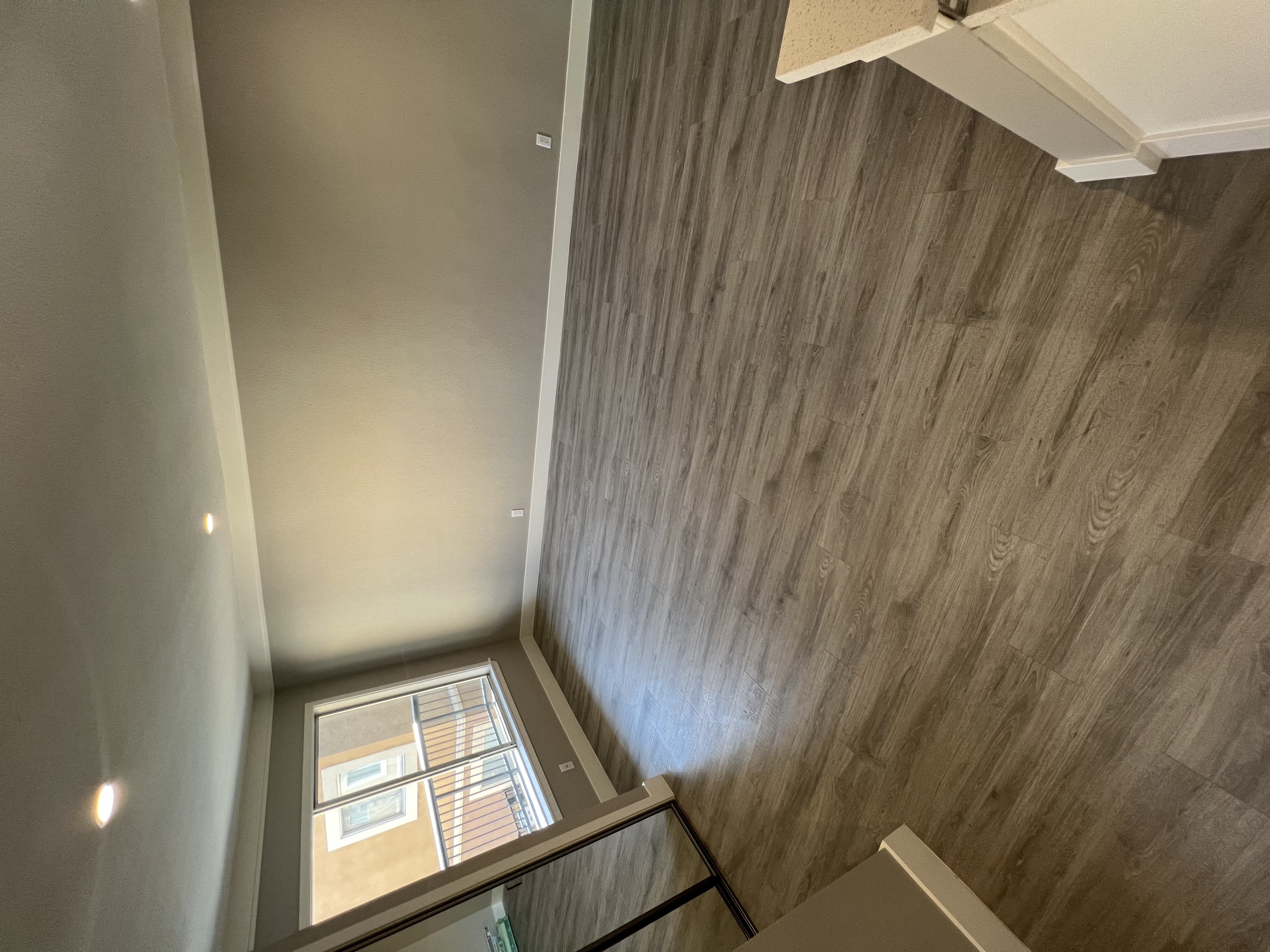 View into living room with wood look flooring, recessed lighting, and well lit almost floor to ceiling window