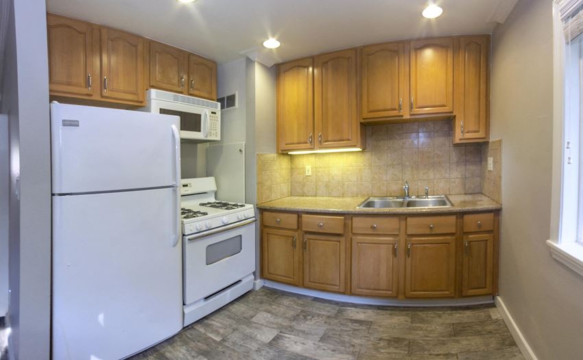 Kitchen View of kitchen with wood look flooring, white appliances, brown cabinets