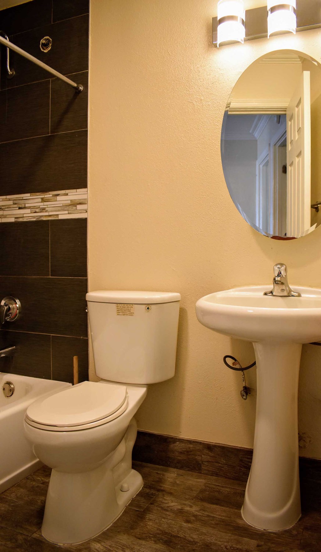 Bathroom featuring tiled tub shower combo, toilet, sink and mirror