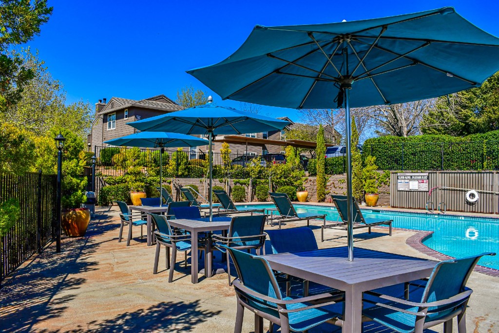 View of community pool with seating and lounge chairs